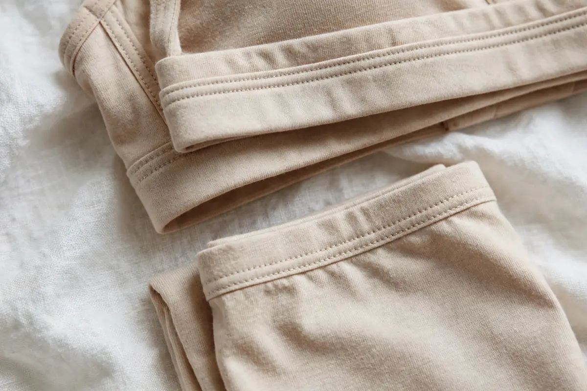 Close-up of beige cotton jersey fabric and double stitching of the set